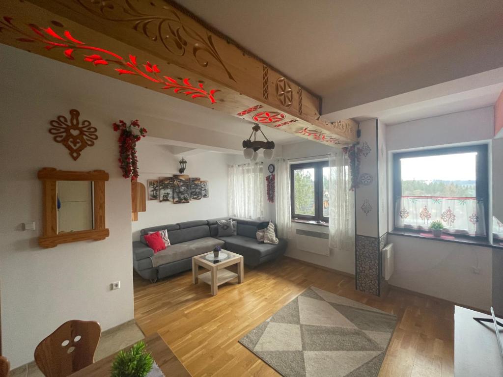 sala de estar con sofá y mesa en Apartament Gawra Sauna & Jacuzzi, en Zakopane