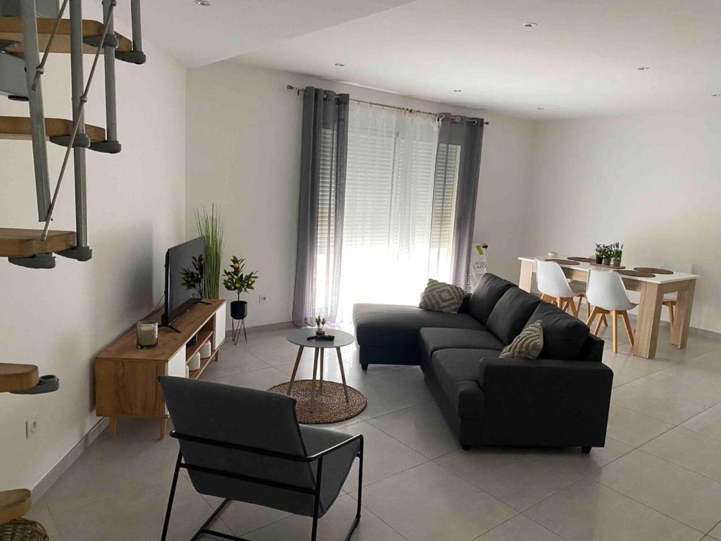 een woonkamer met een bank en een tafel bij Propriete de 3 chambres avec terrasse et wifi a Quetigny in Quétigny