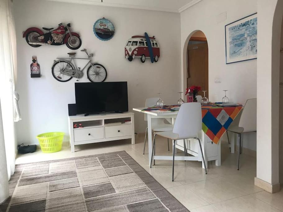 uma sala de estar com uma televisão e uma mesa com mesa; em La Casa Algorfa Pool View Apartment by Delta em Coxhoe