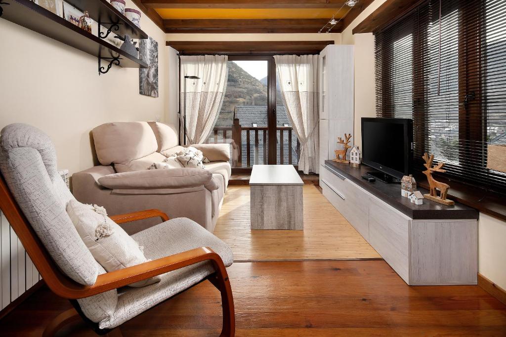 sala de estar con 2 sillas y TV en Apartamento La Santeta de Aran, en Vielha