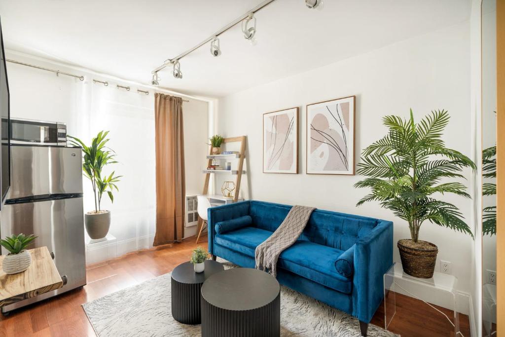 a living room with a blue couch and potted plants at 69-4D Trendy Lower East Side 1B BRAND NEW in New York