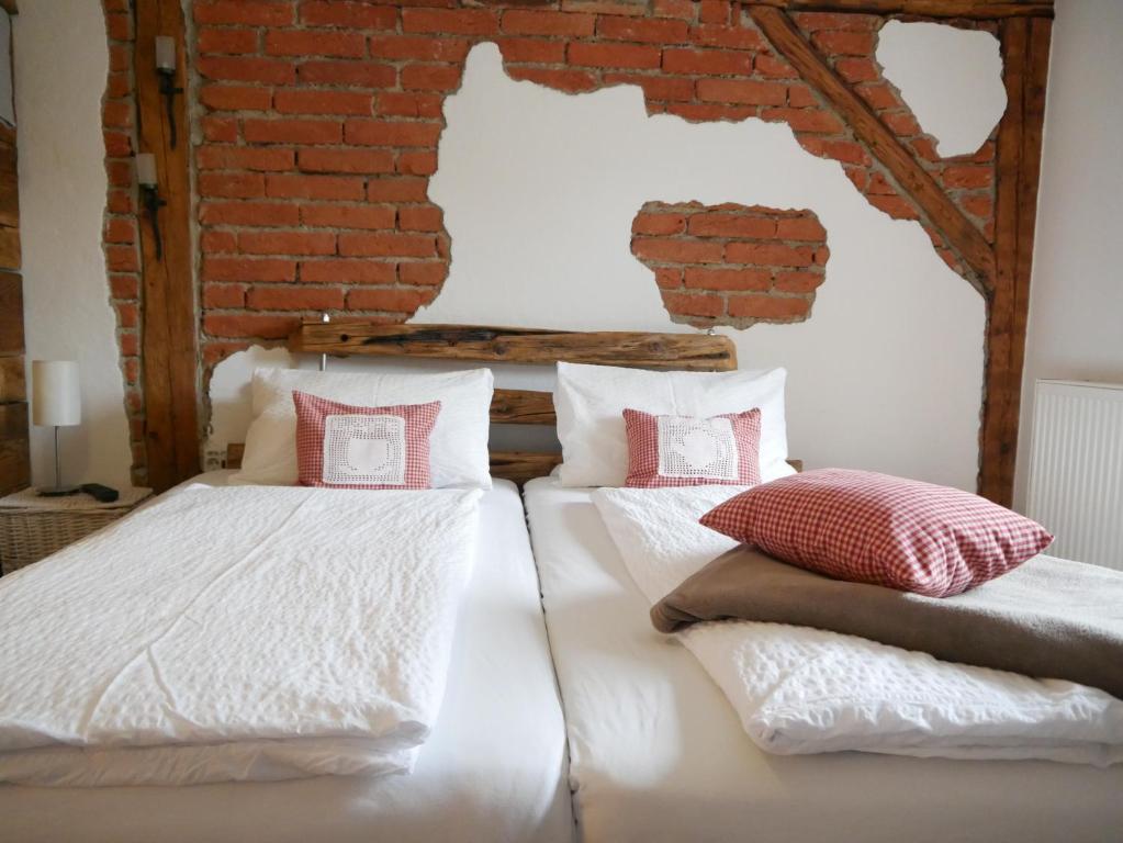 2 camas en una habitación con una pared de ladrillo en Antonia´s Kaffeehäferl, en Eibiswald