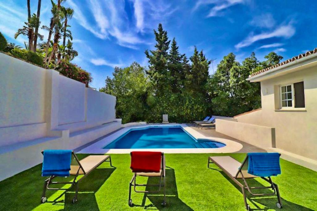 un patio con sillas y una piscina en 5 bedrooms chalet with shared pool and wifi at Marbella, en Marbella