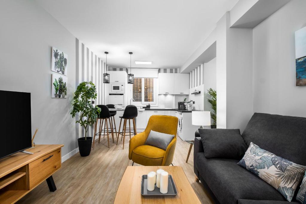 ein Wohnzimmer mit Couch und Küche in der Unterkunft Apartamento Aloha Torres (La Carihuela) Torremolinos in Torremolinos