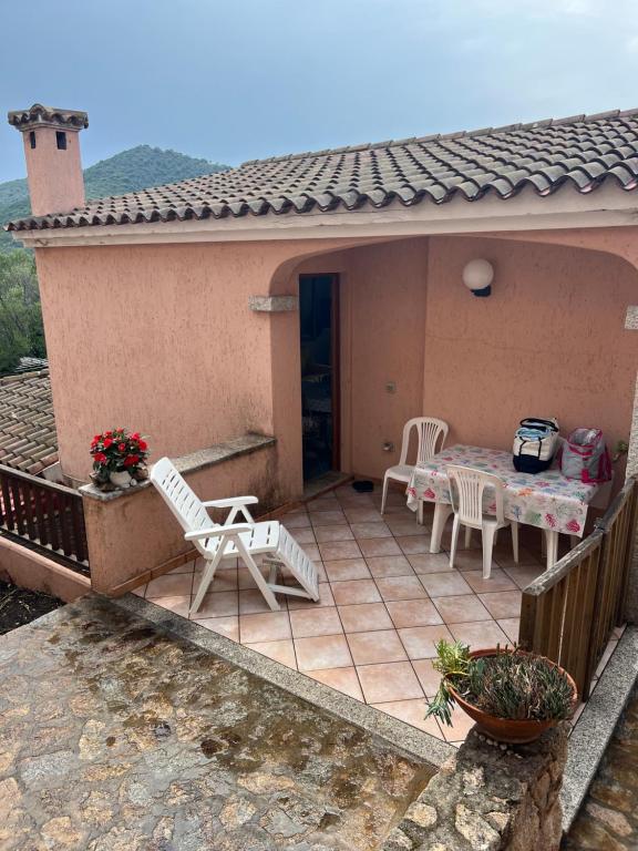 eine Terrasse mit einem Tisch und Stühlen auf einem Haus in der Unterkunft Casa vacanze a Budoni in Budoni