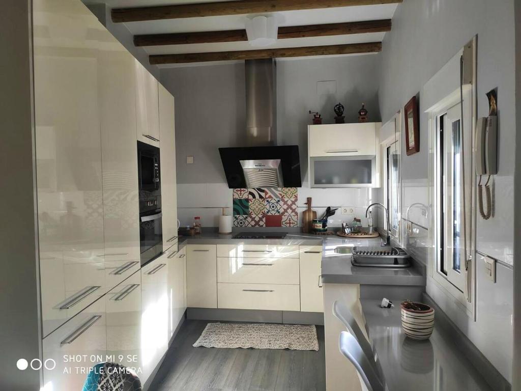 eine weiße Küche mit weißen Schränken und einem Waschbecken in der Unterkunft 2 bedrooms apartement with wifi at Sevilla in Sevilla