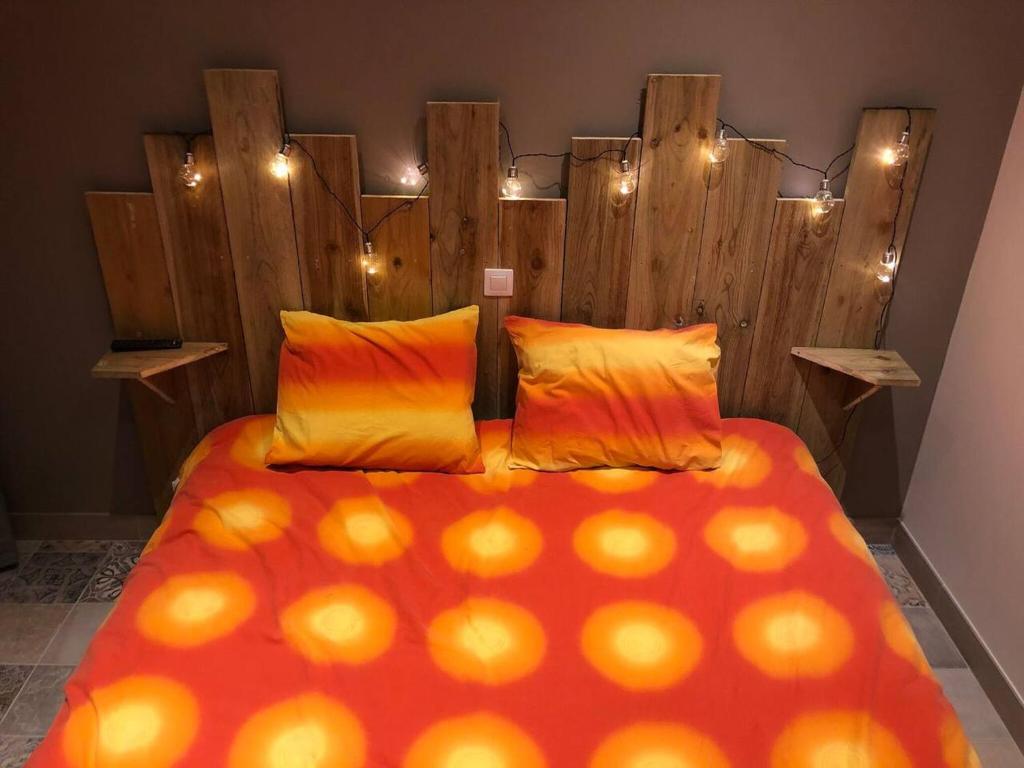 une chambre avec un grand lit avec une tête de lit en bois dans l'établissement Chalet charmant à Clermont-Créans avec piscine partagée, à La Flèche