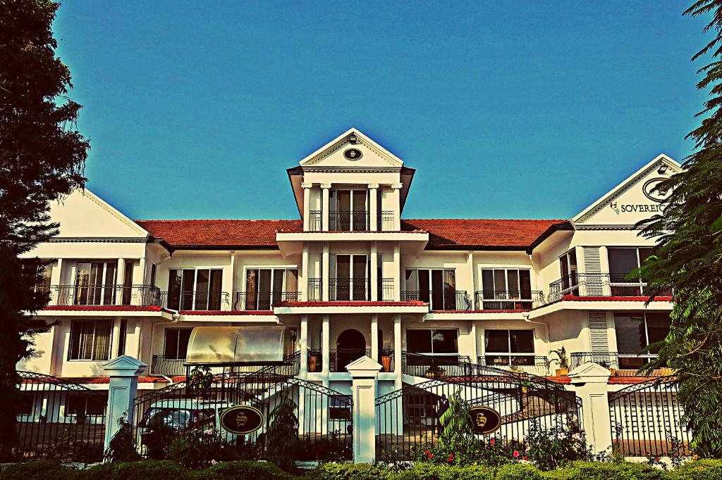 un grand bâtiment blanc avec un toit rouge dans l'établissement Sovereign Hotel, à Kisumu