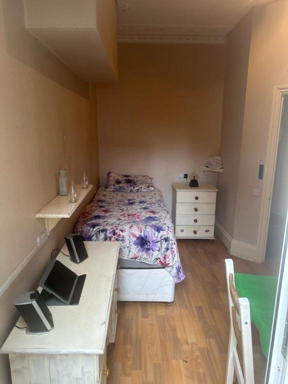 una piccola camera con un letto e due tavoli di Best east London location a Londra