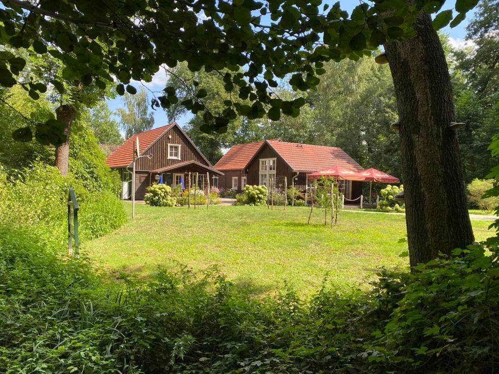 une maison dans une cour avec un arbre et une pelouse dans l'établissement Ferienhof Bludnik, à Kaupen