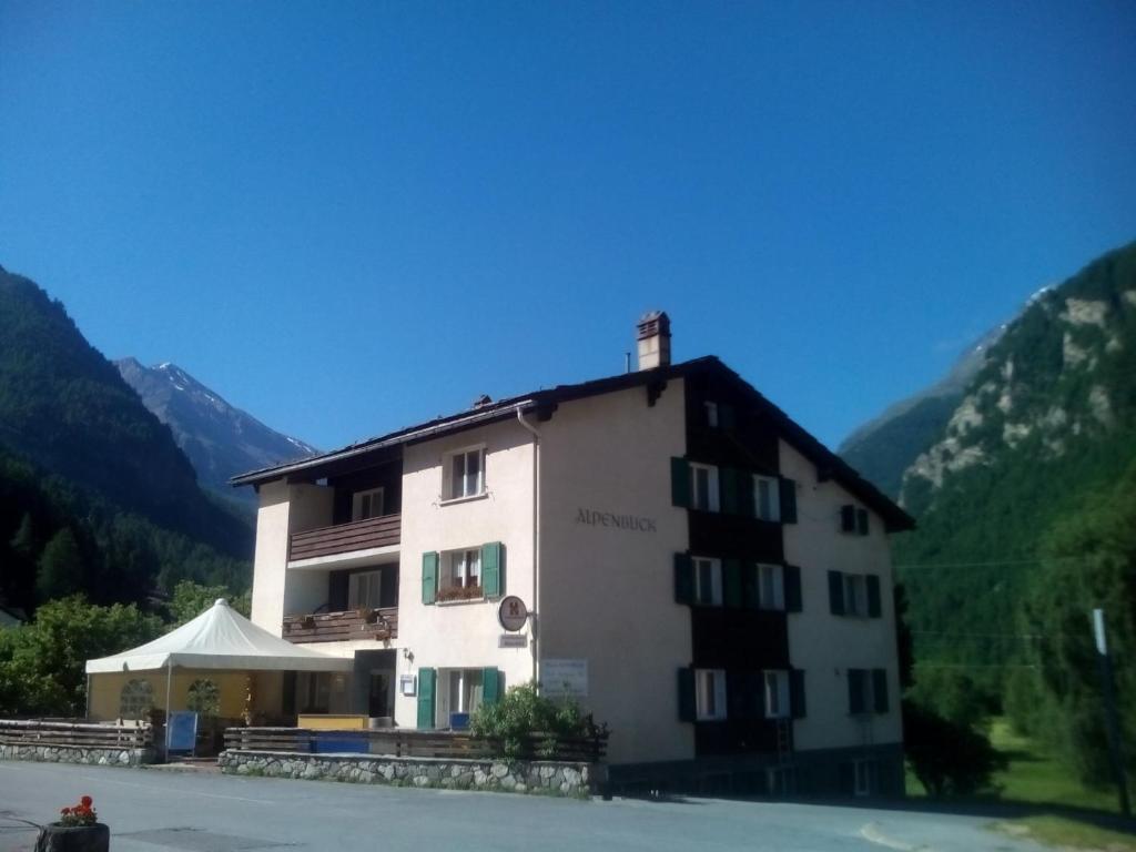 Un grand bâtiment blanc avec des montagnes en arrière-plan dans l'établissement Hotel Klein Matterhorn, à Randa