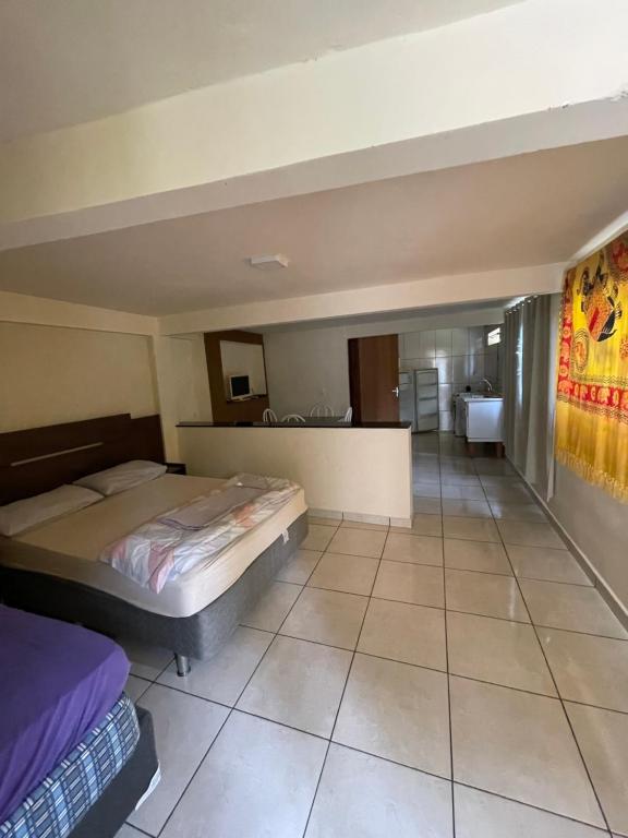 a bedroom with two beds and a bathroom at Kitnet agradável Alto Caparaó MG in Caparaó Velho