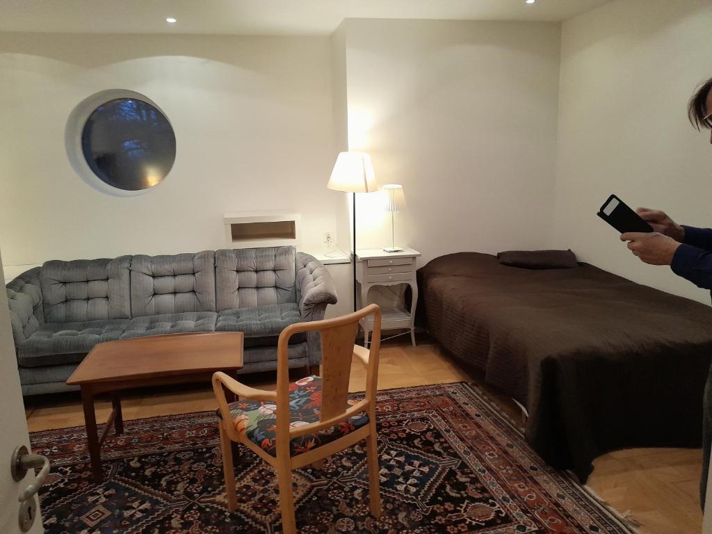 a living room with a bed and a couch at Floravägen 11 in Lidingö