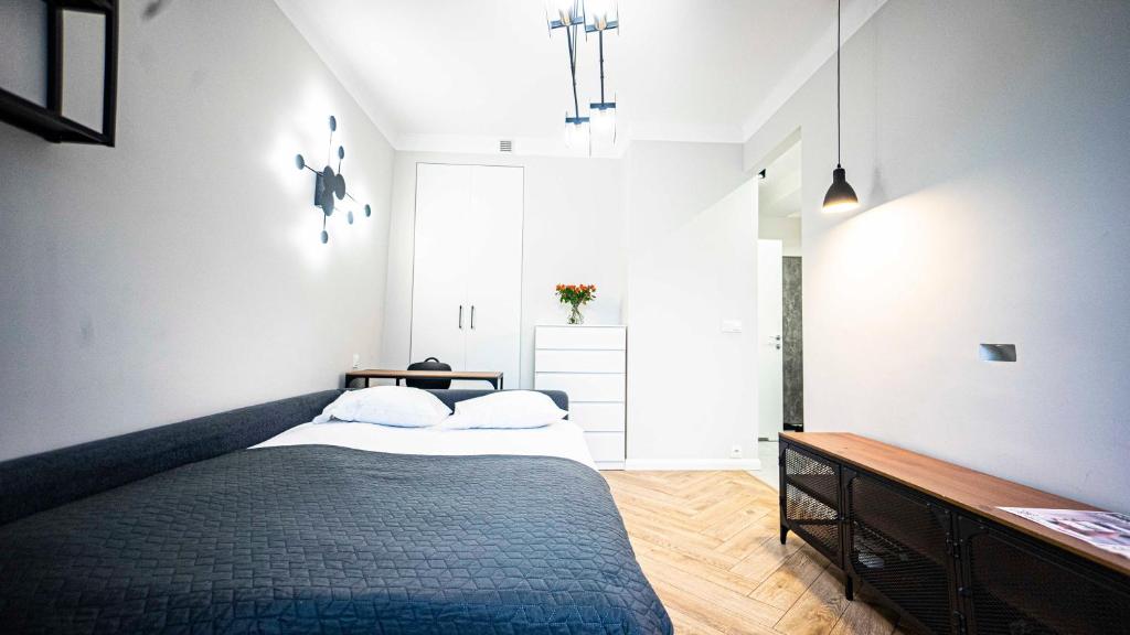 1 dormitorio con 1 cama grande y 1 mesa en Apartament w Centrum Warszawy, en Varsovia