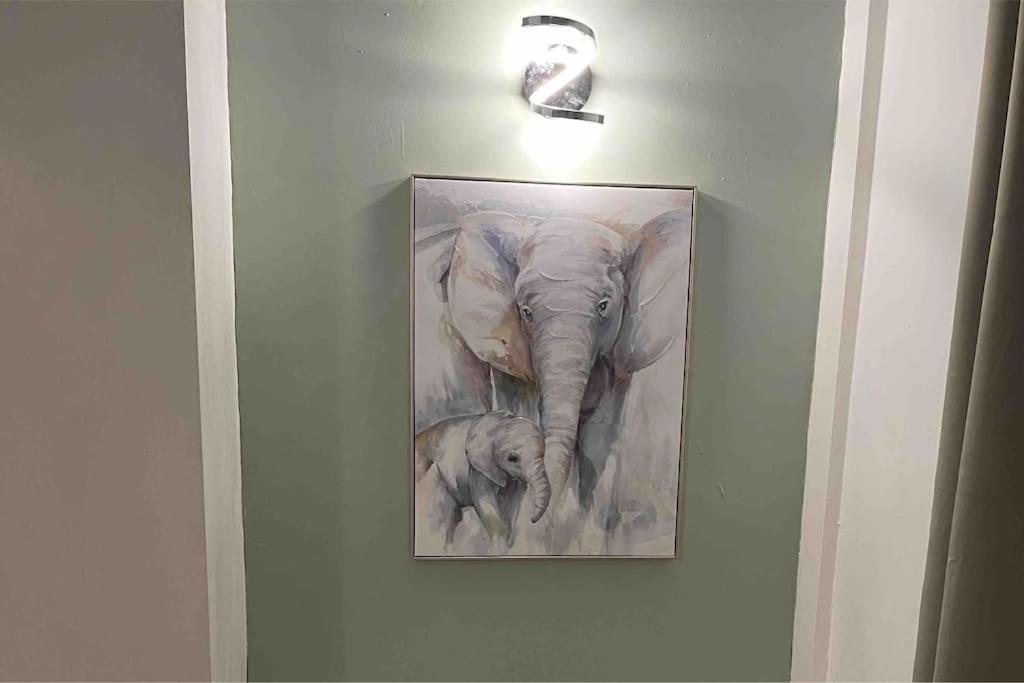 a painting of an elephant and a baby elephant on a wall at Sage Home - sweet & snuggly in Denton