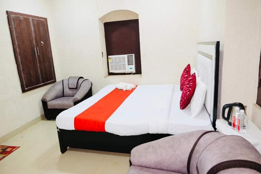 une chambre d'hôtel avec un lit et une chaise dans l'établissement millenium homestay, à Varanasi
