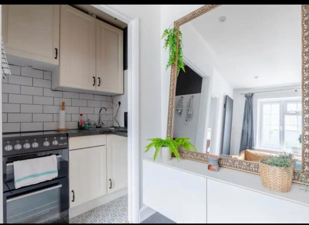 een keuken met witte kasten en een raam bij Edgware Road Apartment in Londen