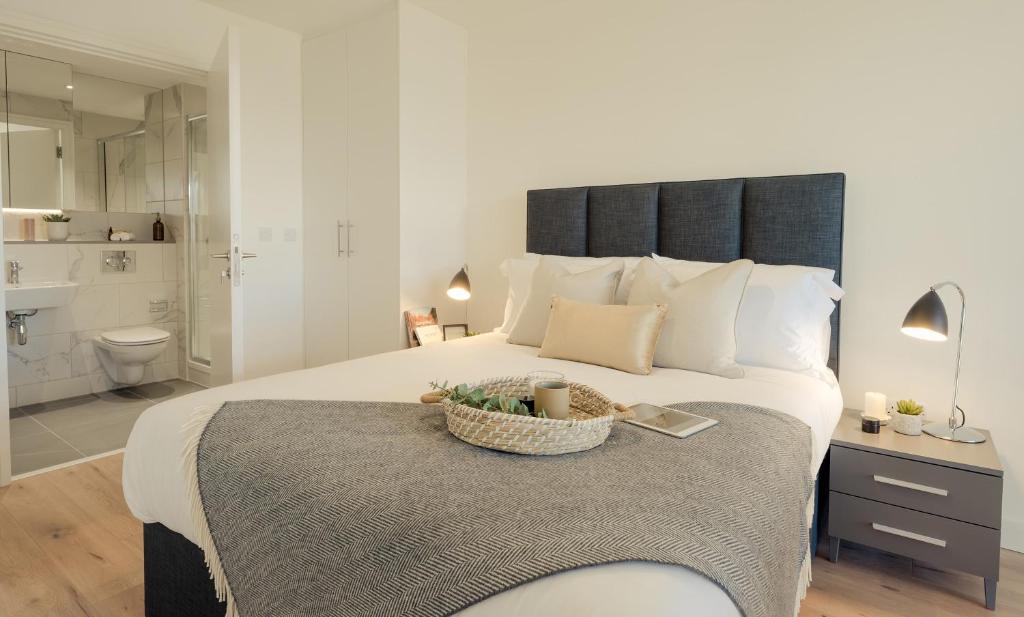 1 Schlafzimmer mit einem großen Bett und einem Badezimmer in der Unterkunft Luxury Apartment Cherrywood Dublin 18 in Dublin