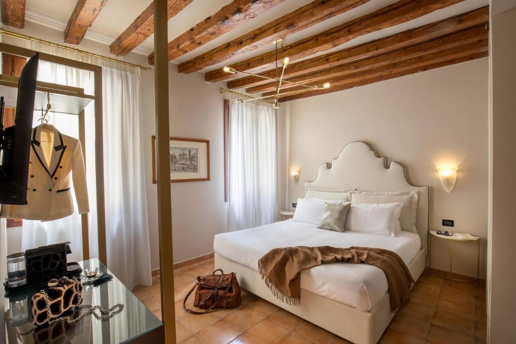 um quarto com uma grande cama branca num quarto em Daplace - Antica Casa Coppo em Veneza