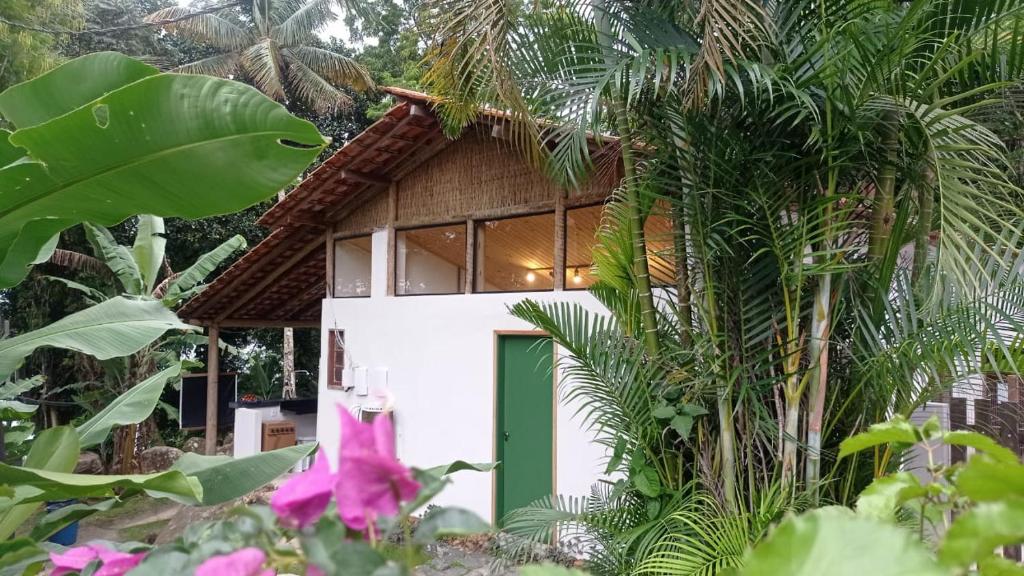a house with a green door and some plants at Pousada Sobre A Rocha in Praia de Araçatiba