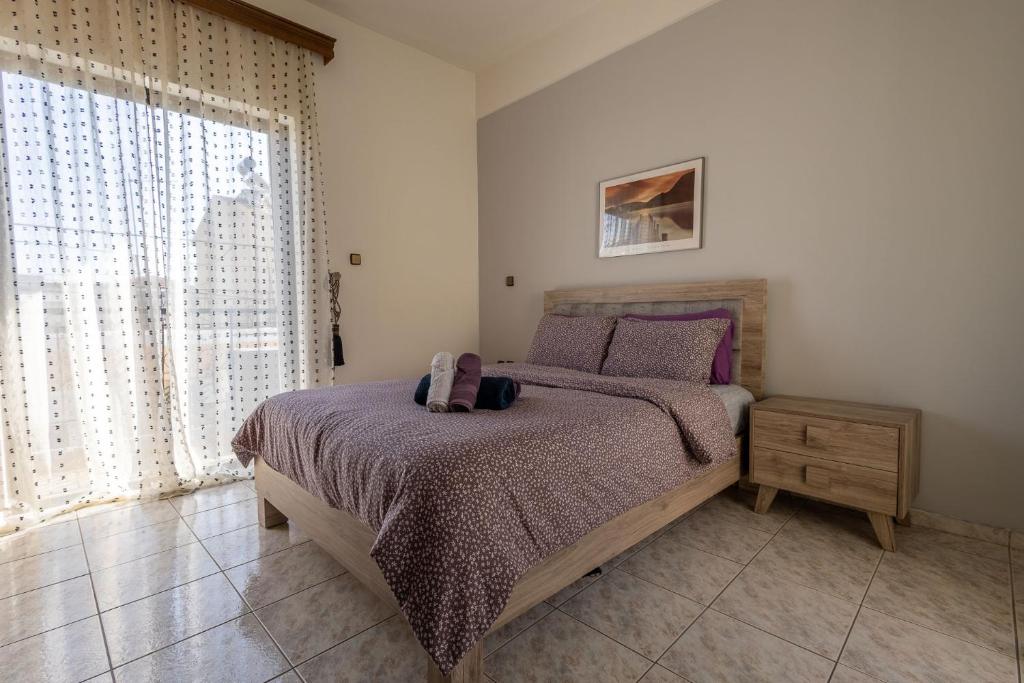 a bedroom with a bed with a purple bedspread at Special Apartment in Larisa