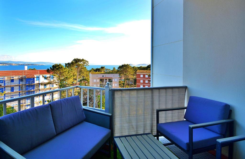balcón con banco y 2 sillas en Apartamento con vistas al Náutico de San Vicente en O Grove