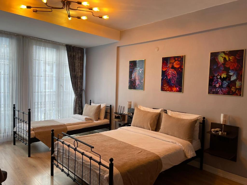 een slaapkamer met 2 bedden en een raam bij TAKSİM SqUARE PARK HOTEL in Istanbul