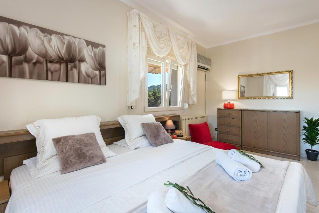 sypialnia z dużym białym łóżkiem i oknem w obiekcie Villa INVA Korfu w mieście Kavos