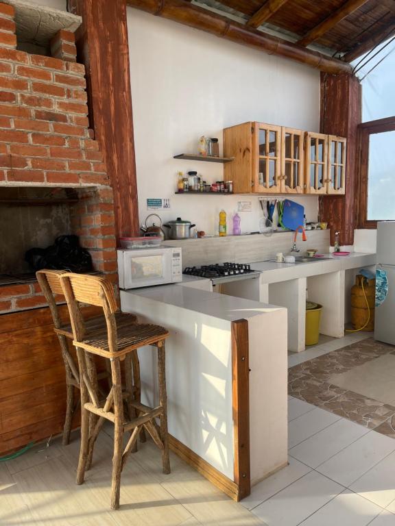 cocina con encimera y silla en una habitación en Habitación matrimonial con vista al mar-wanderlust, en Santa Elena