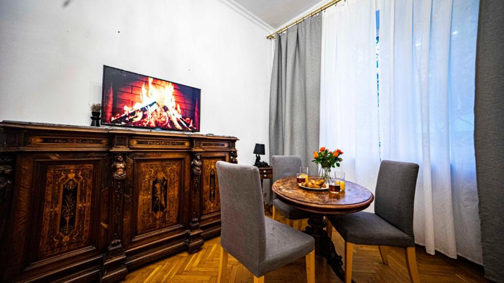 uma sala de estar com uma mesa e uma televisão num armário em Apartment with Antique furniture in The Old Town, metro em Varsóvia