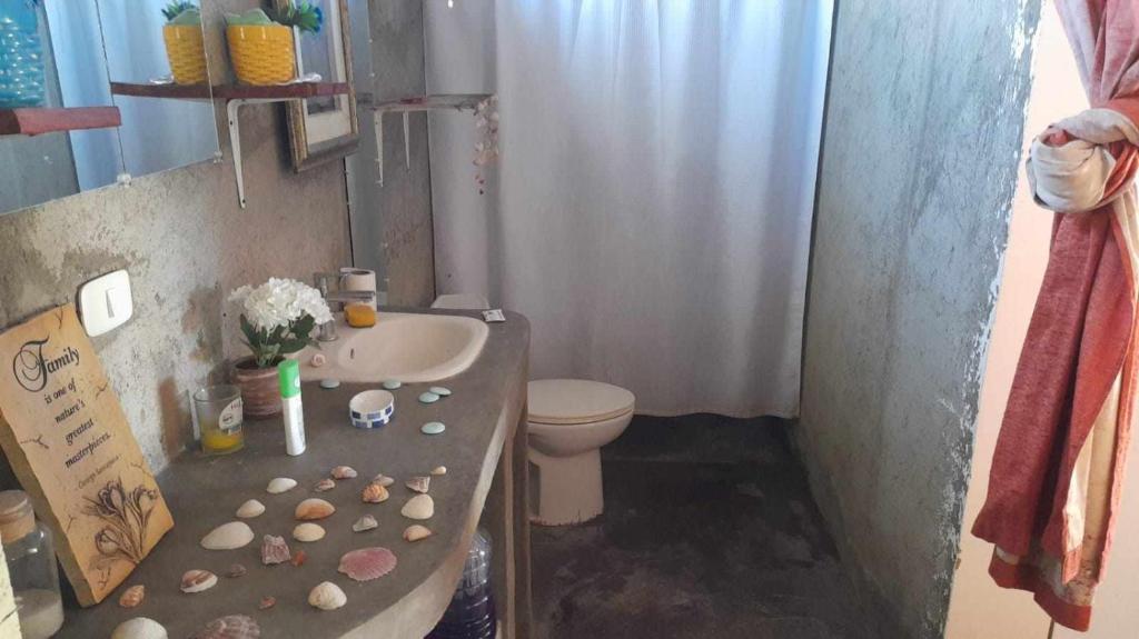 a bathroom with a sink and a toilet at Fullmoon Guasacate House in Popoyo