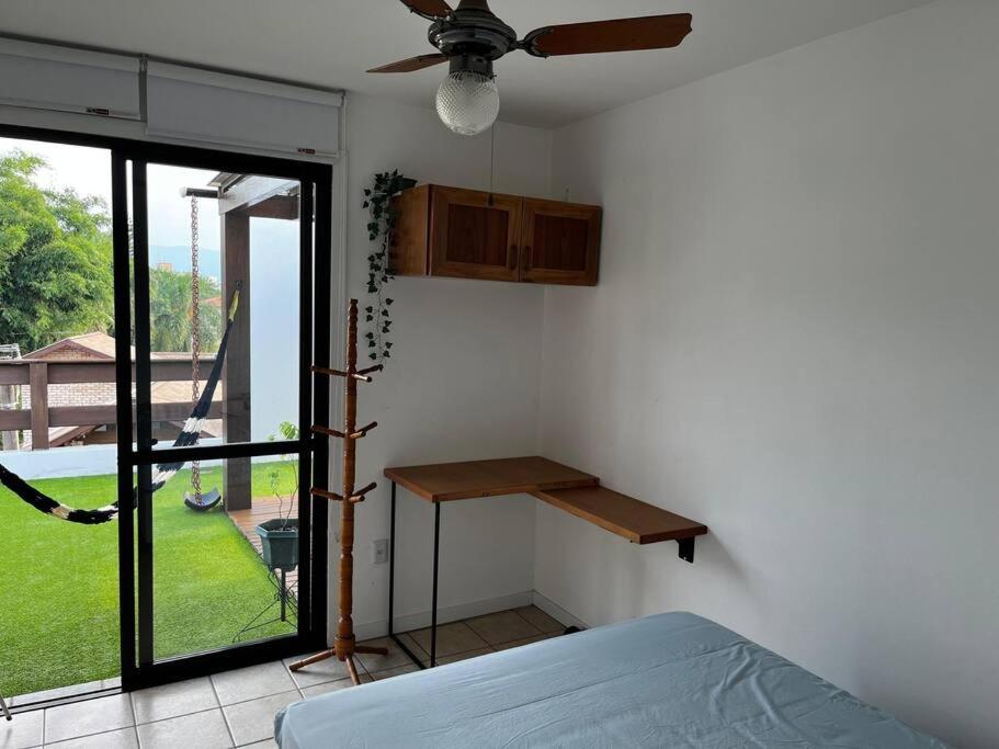 um quarto com uma cama, uma mesa e uma janela em Cobertura com Vista para o Mar em Florianópolis