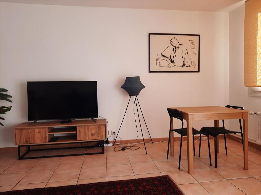 sala de estar con TV y mesa en Grande chambre lumineuse dans un grand t3, en Aix-en-Provence
