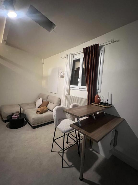 een woonkamer met een bank en een tafel bij Le cosy chic 16 in Parijs