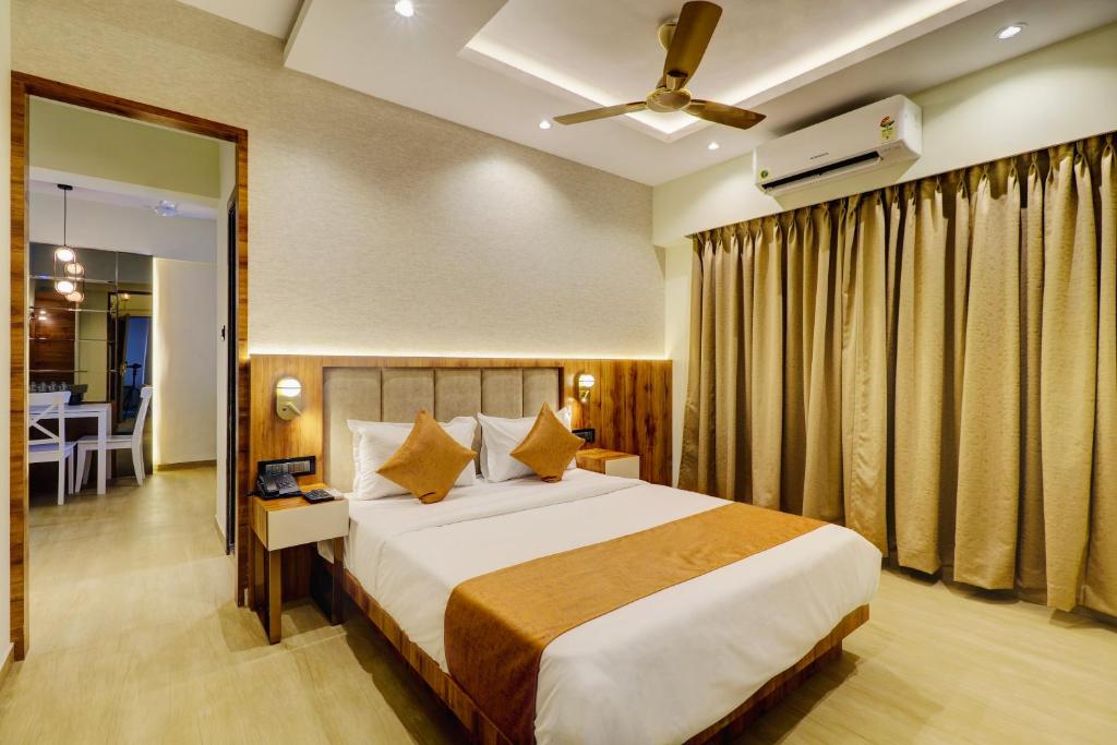 a bedroom with a large bed and a dining room at Home2 Studio Apartments in Mumbai