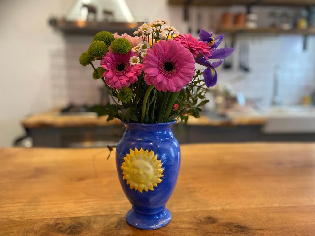 a blue vase filled with flowers on a table at Church Retreat - A Magnificent Seaside Apartment-Award Winning in Hastings