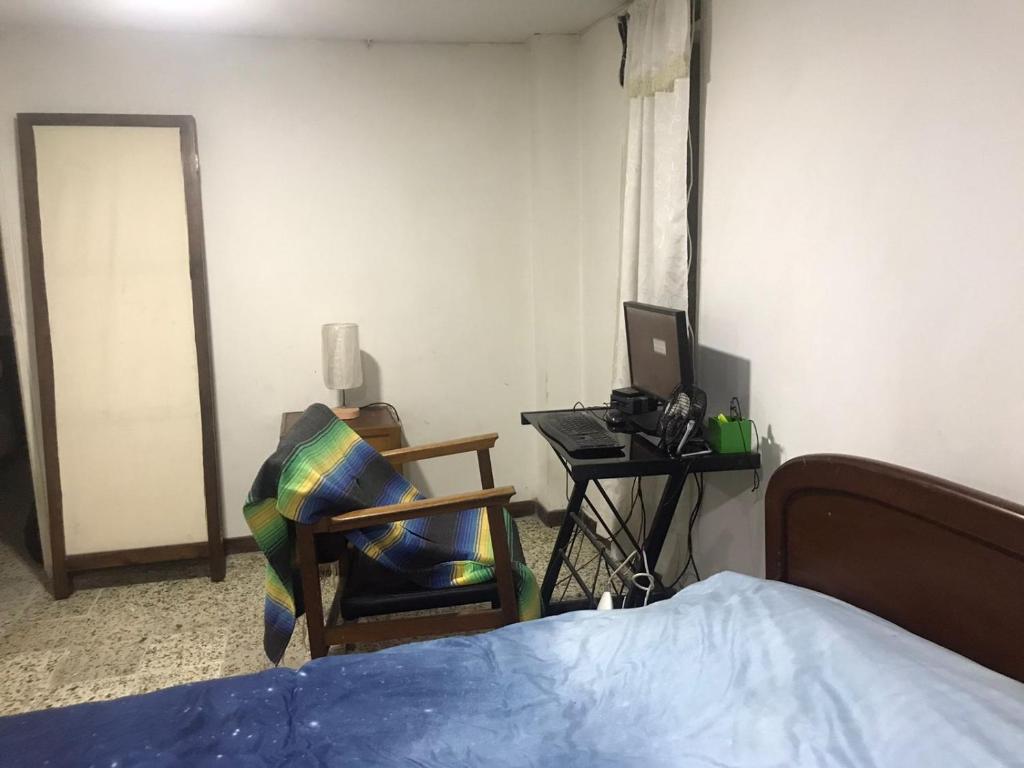 a bedroom with a bed and a desk with a computer at CASA EN EL QUINDÍO in Armenia