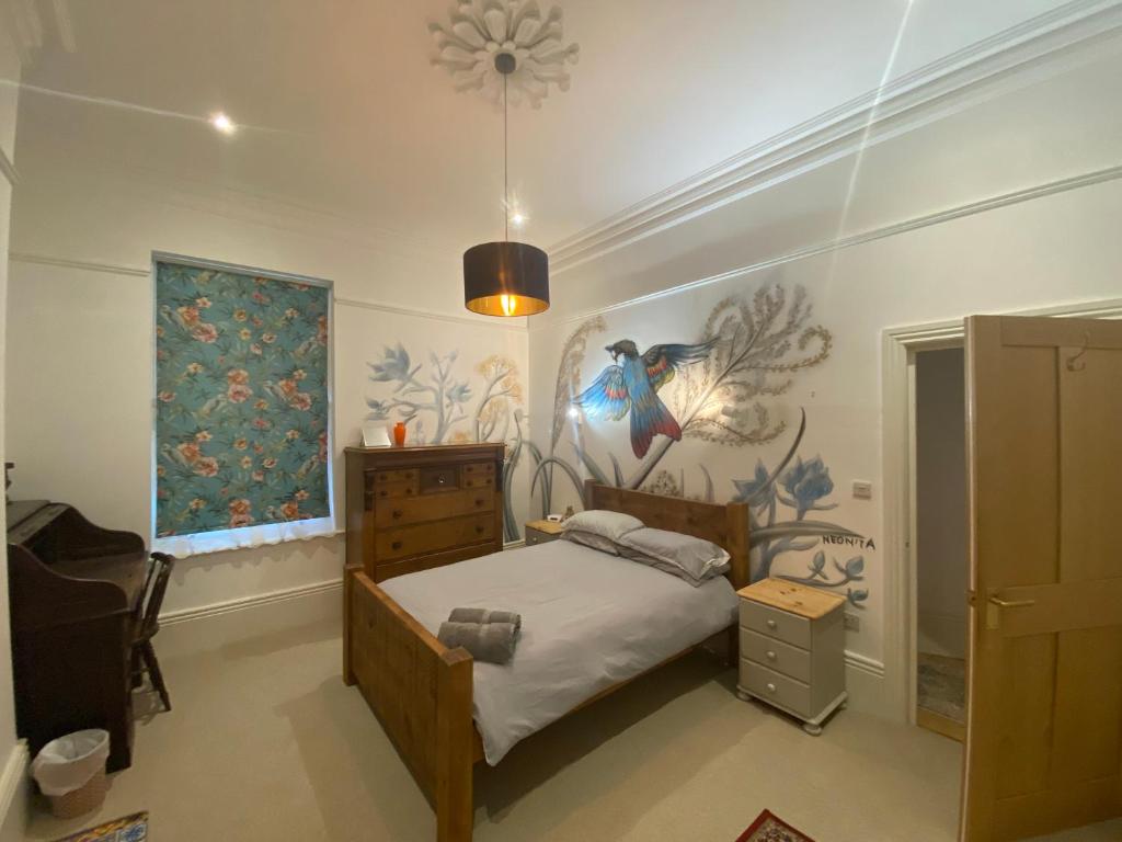 1 dormitorio con 1 cama y una pintura en la pared en Church Retreat - A Magnificent Sea Side Apartment, en Hastings