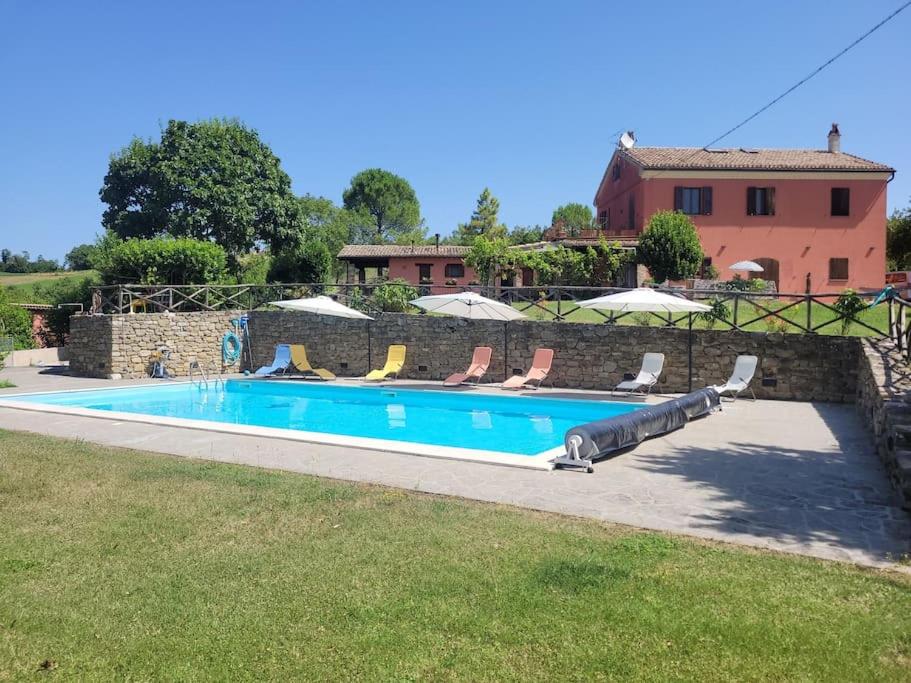 uma piscina com cadeiras e uma casa em Agriturismo Merlino - Natur pur em Pergola