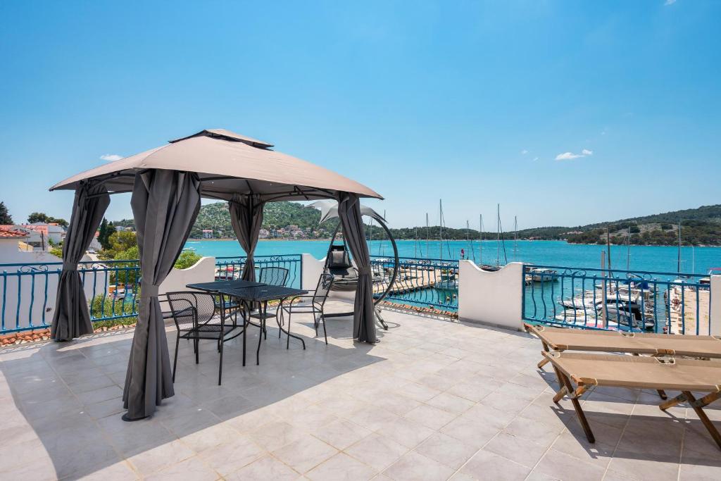 a patio with a table and chairs and the water at Irene Bed & Breakfast Tisno in Tisno