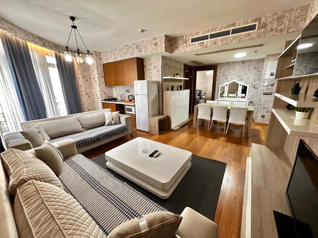 uma sala de estar com um sofá, uma mesa e uma cozinha em İstanbul Houses Sabiha Gökçen Airport Hotel em Istambul