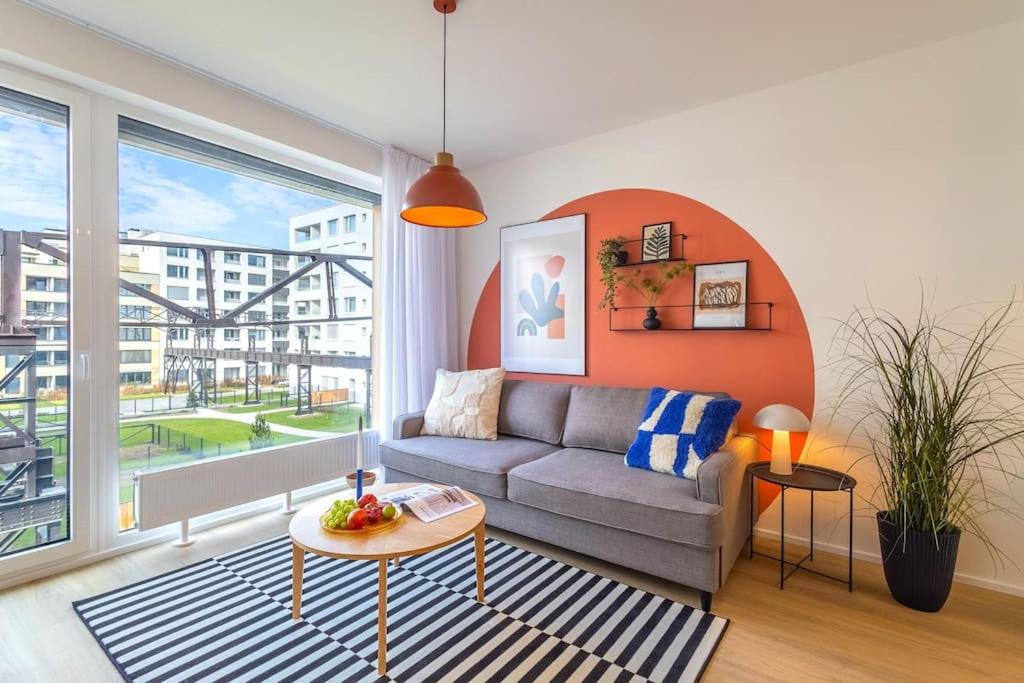 a living room with a couch and a large window at Design apartment • Balcony • Free Parking • Yoga • 10 mins to center in Prague