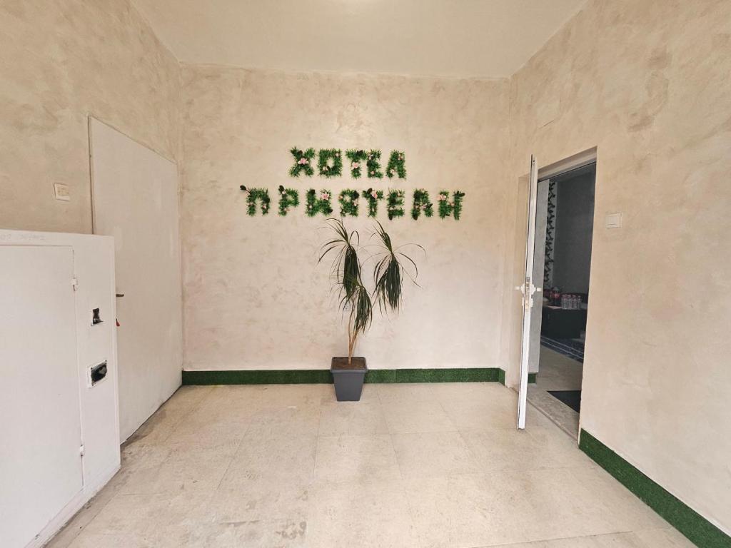 an empty room with a plant on the wall at Хотел Приятели in Vratsa