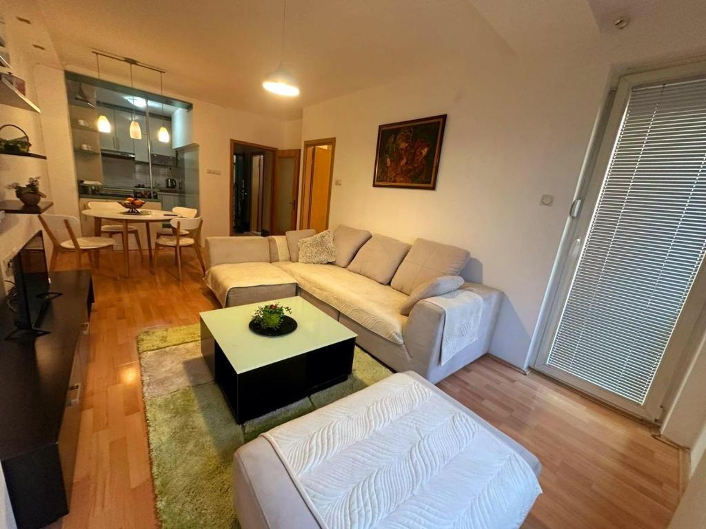 uma sala de estar com um sofá e uma mesa em Apartman Azra em Usje
