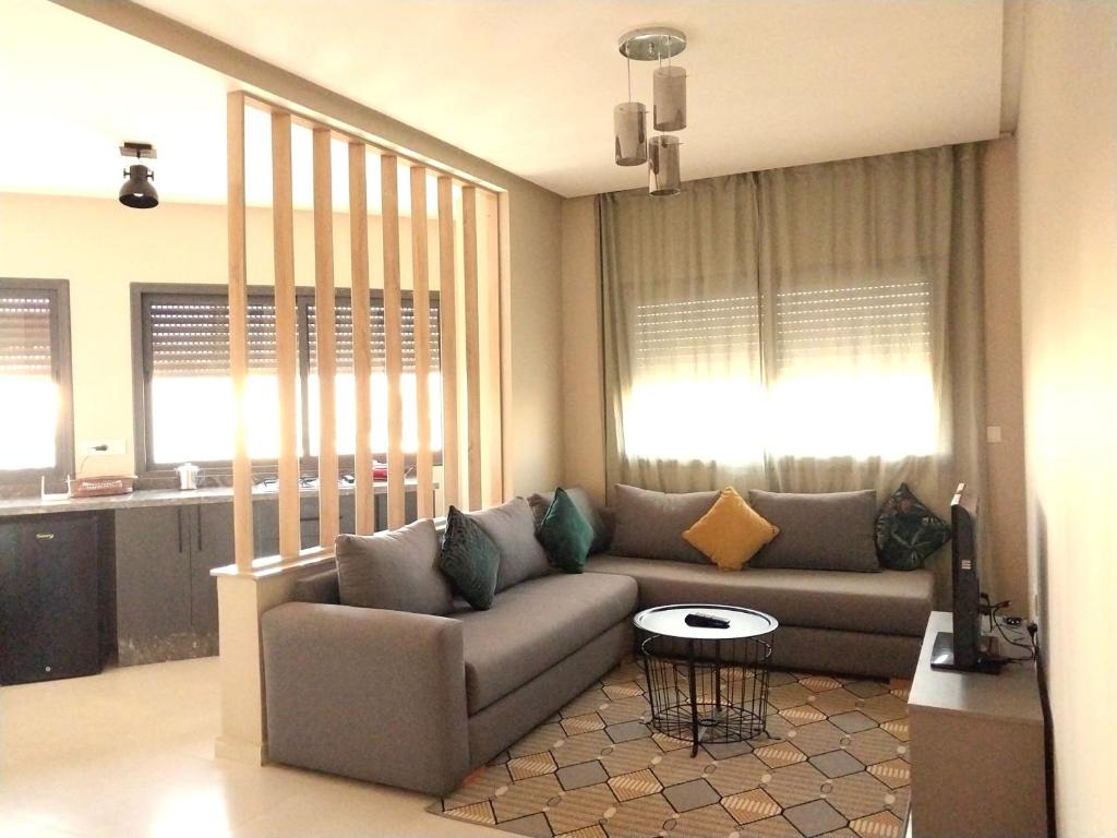 ein Wohnzimmer mit einem Sofa und einem Tisch in der Unterkunft Appart relax aéroport 5 min in Nouaceur