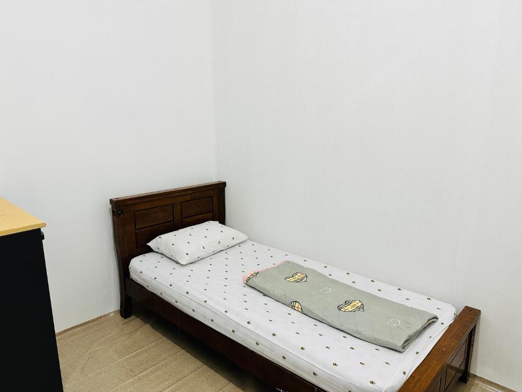 a small bed with a pillow on top of it at Room for single person with sharing washroom in Sharjah