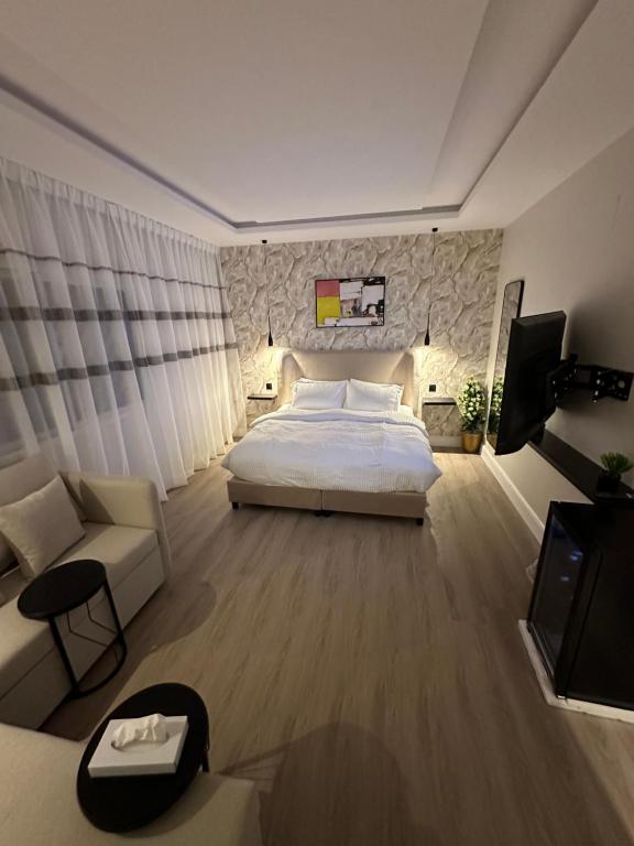 a bedroom with a bed and a couch and a tv at استديو فاخر بمنطقة مركزية in Riyadh