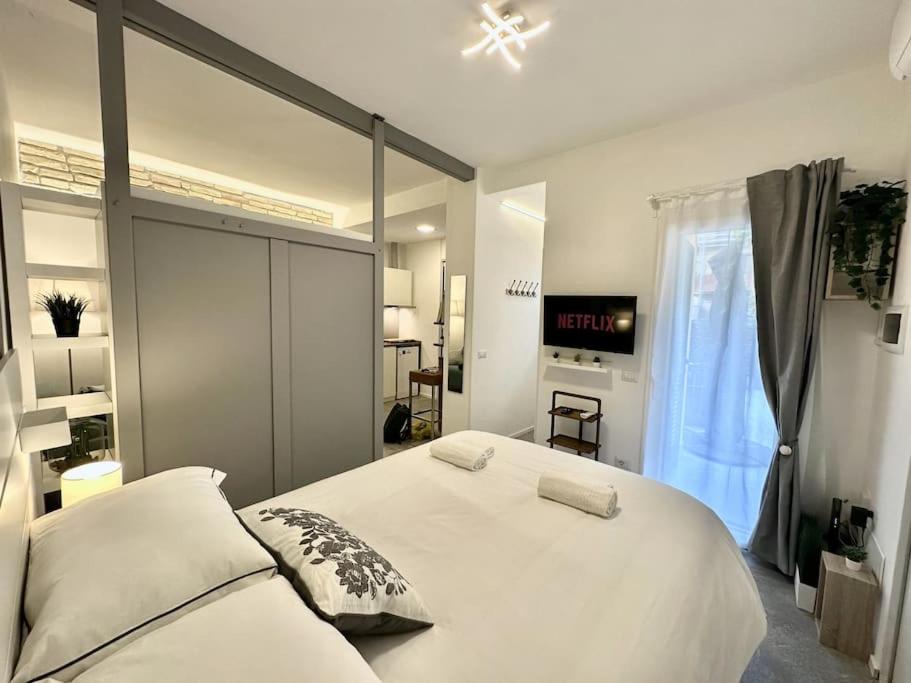 una camera da letto con un grande letto bianco e una finestra di Monolatino Apartment a Roma