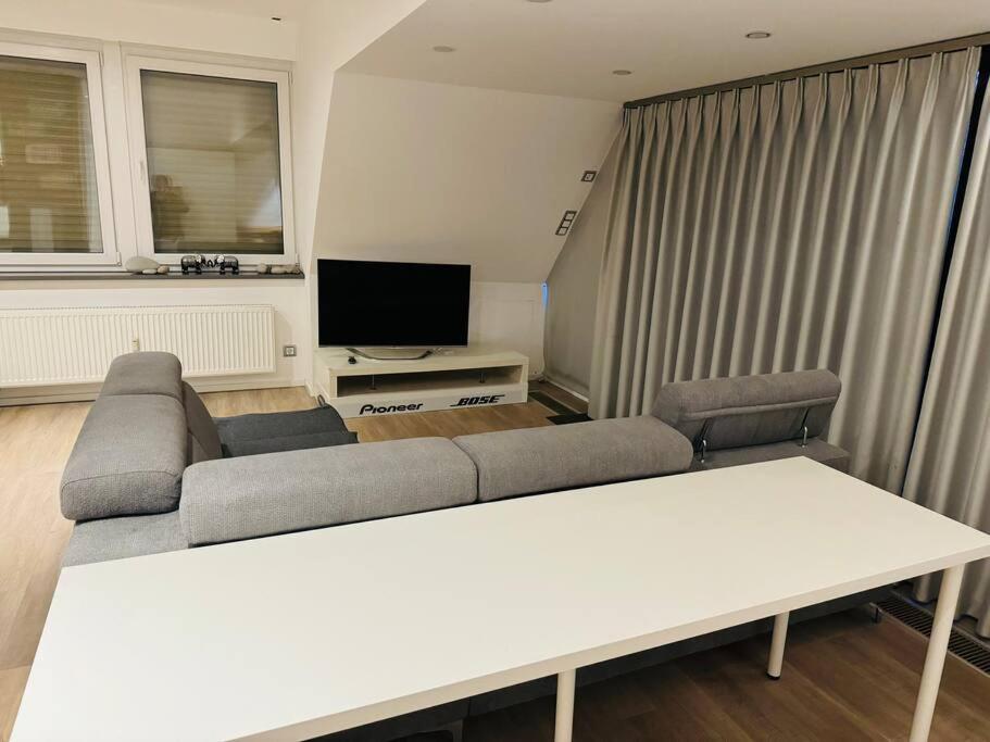 uma sala de estar com um sofá e uma televisão em Schöne Dachgeschosswohnung im Zentrum Erkelenz mit Parkplatz em Erkelenz