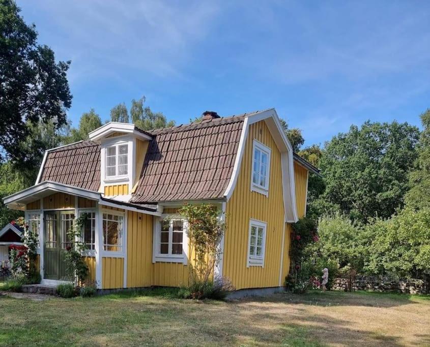 a yellow house with white windows on a yard at Trevliga stugor i Torhamn, perfekt för familjer in Karlskrona